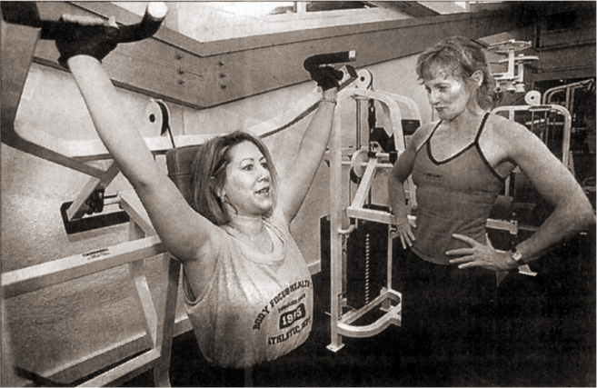Geri Arnais helping Dany Lynn with weight exercises